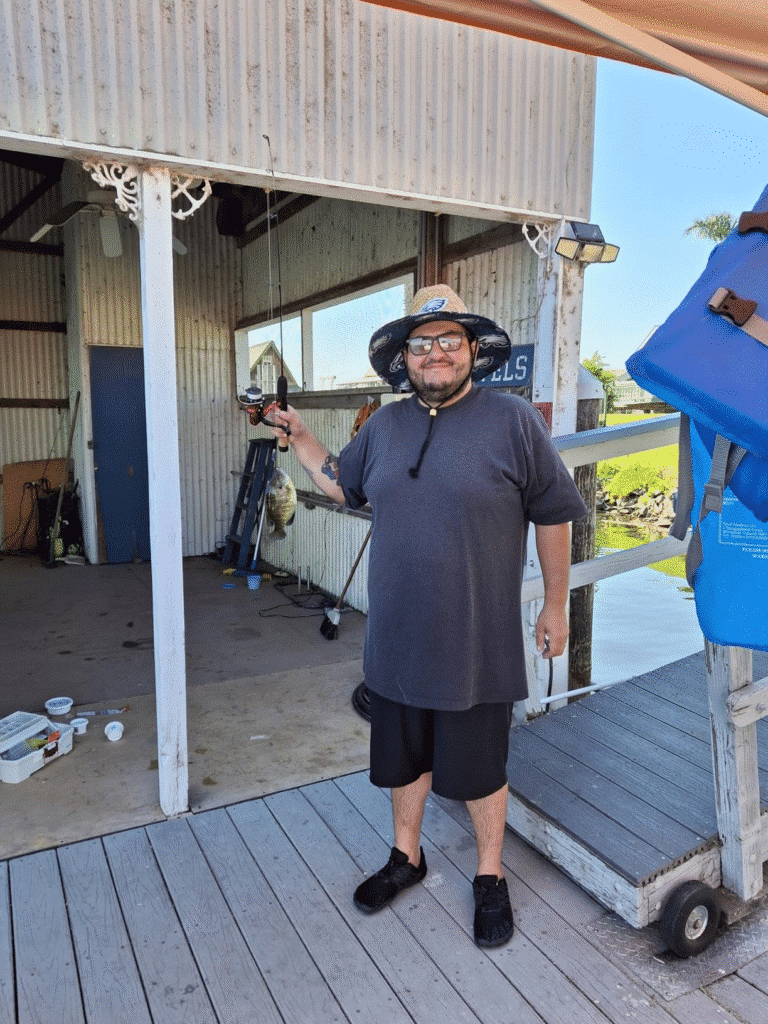 Fisherman standing on a dock wearing a straw lifeguard hat with custom logo, showcasing outdoor use and comfort.