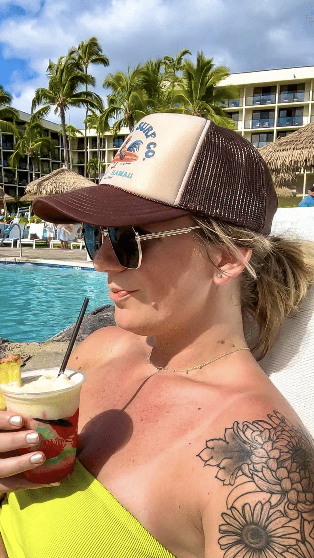 Poolside lifestyle shot of a custom foam trucker hat with mesh back and surf logo—beach resort wholesale style.