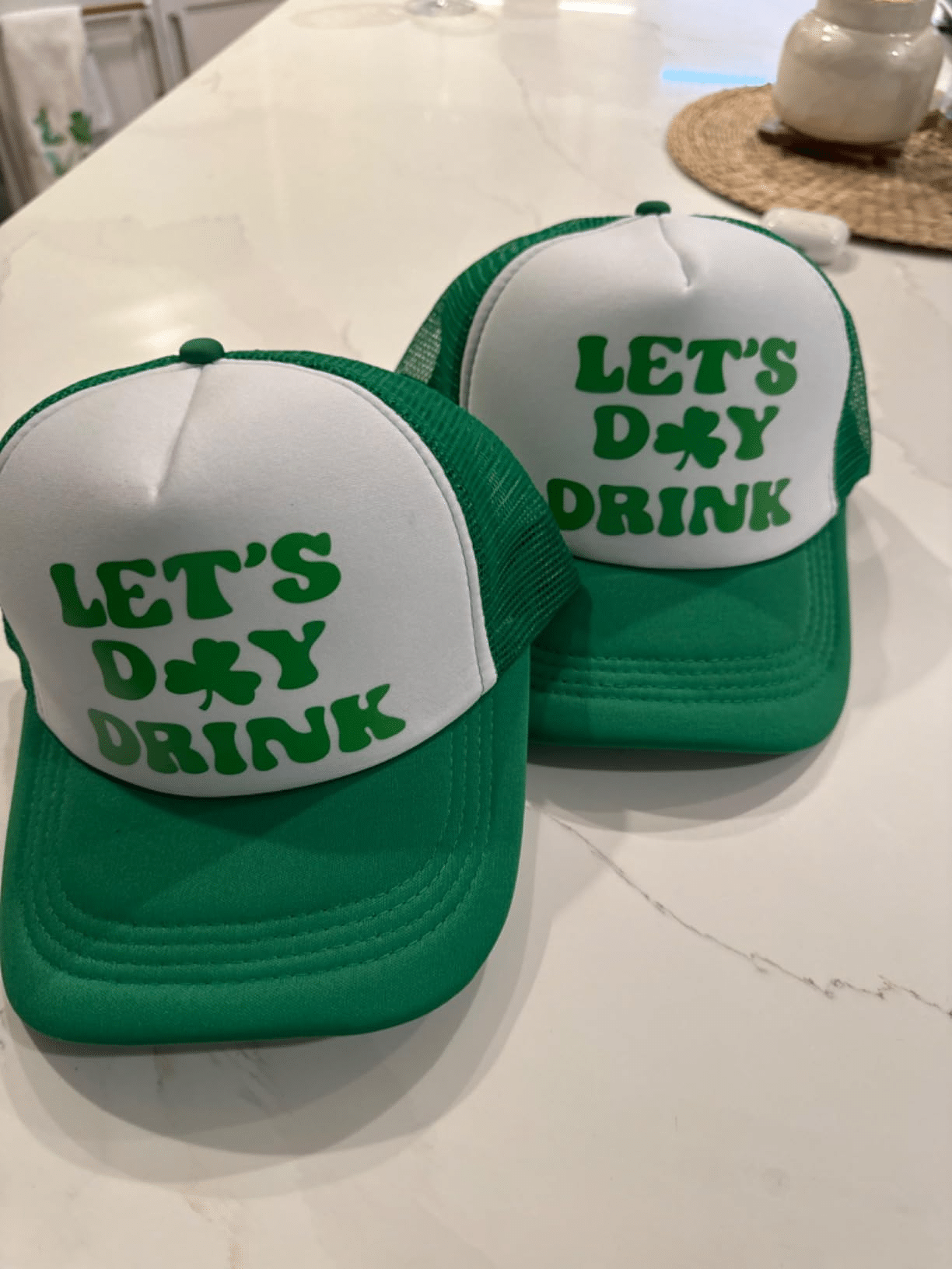 Two green foam front trucker hats with white foam panels and shamrock “LET’S DAY DRINK” graphic; custom heat-transfer print, snapback mesh.