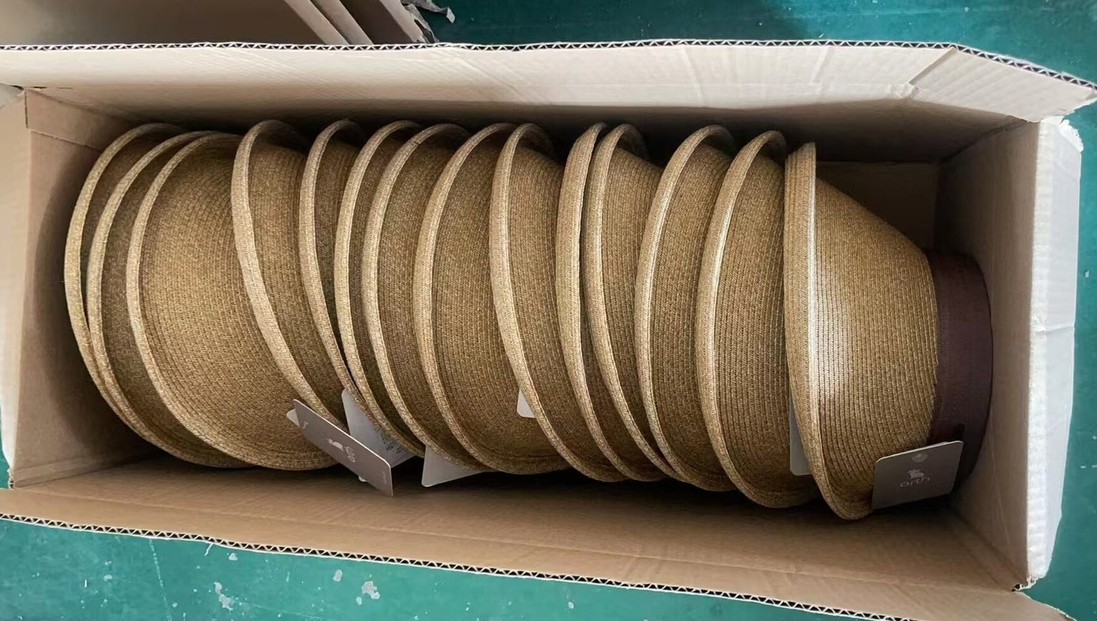 Natural straw sun visor caps neatly arranged for shipment