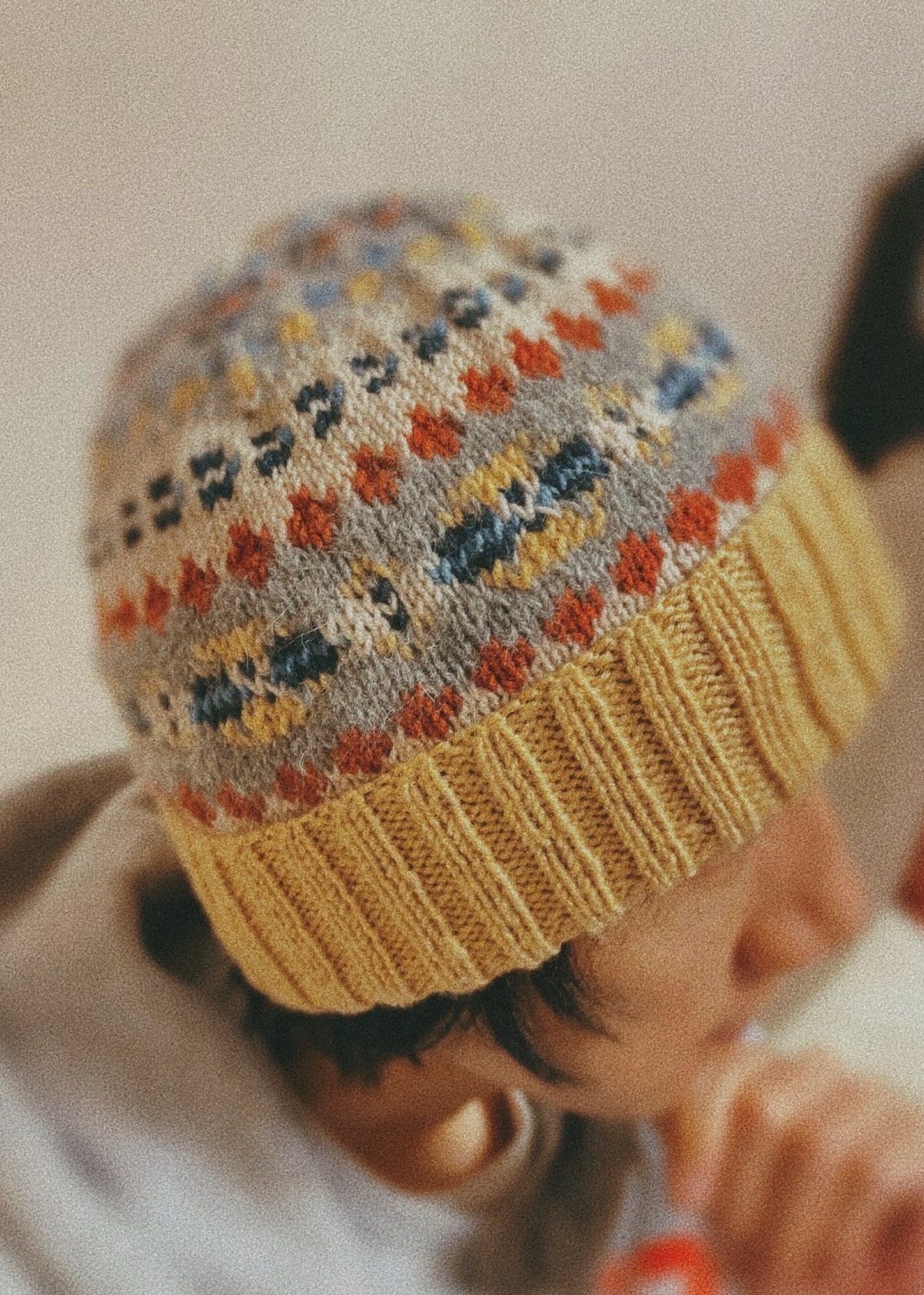 Child in fair-isle kids beanie—holiday gift merchandising.