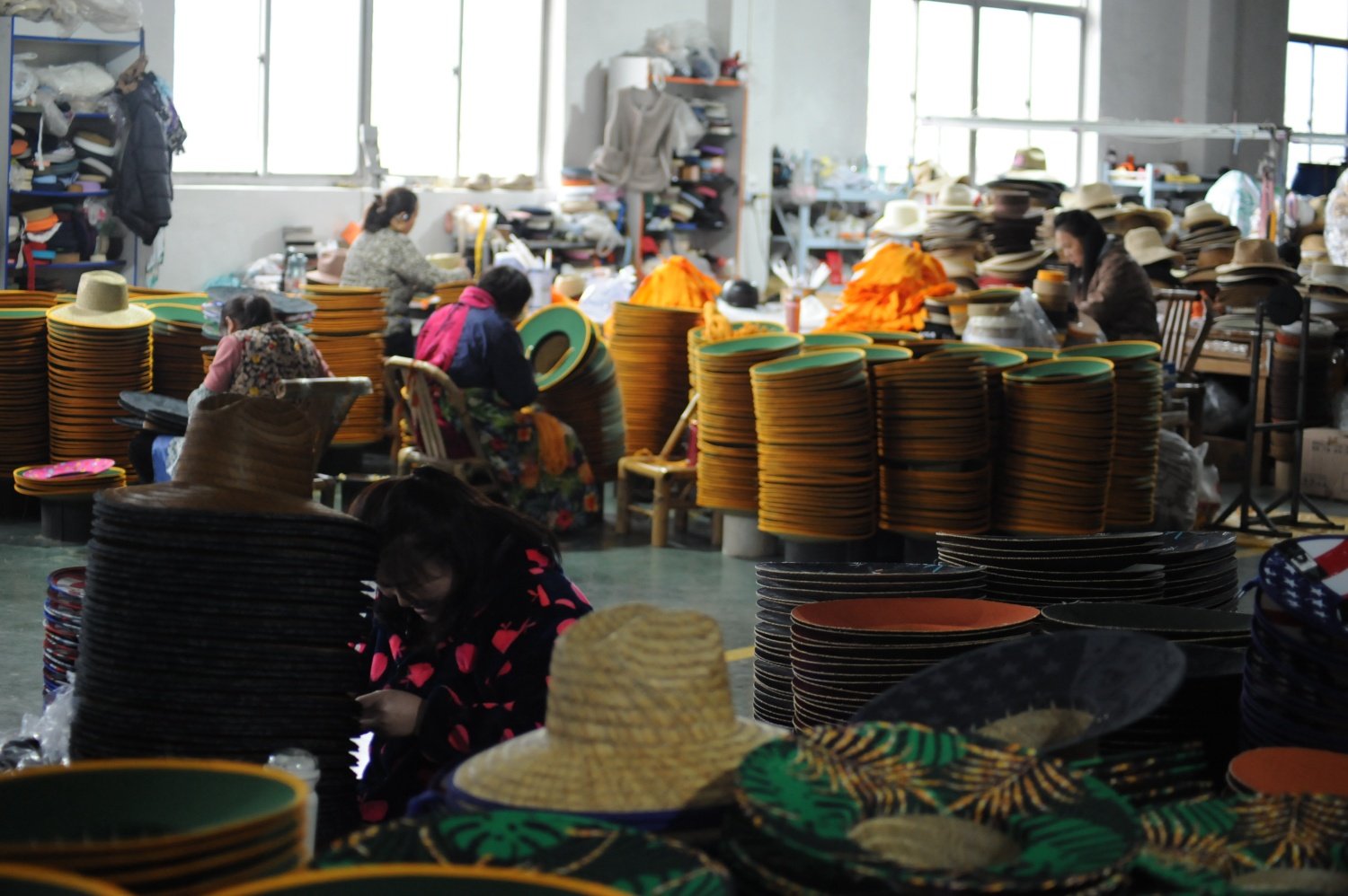 Straw hat manufacturing workshop showing bulk production and quality control process